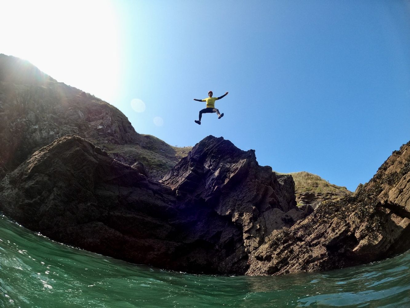 Coasteering cliff jump at Fistral Beach, Newquay, Cornwall